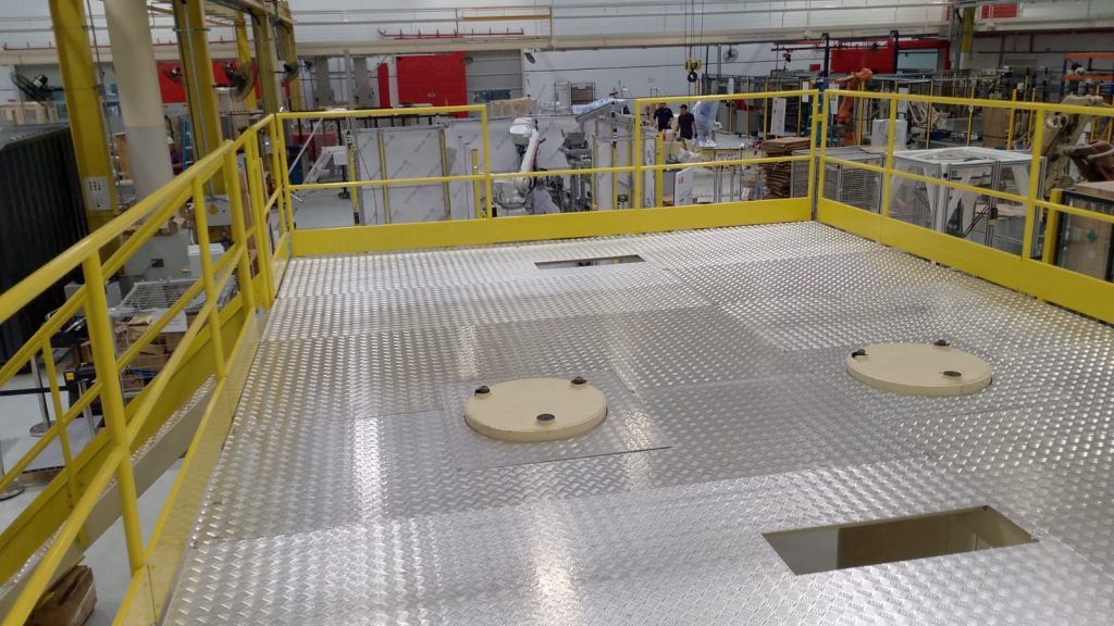 Piso de plataforma metálica em chapa xadrez com guarda-corpo amarelo — ABB Robótica, Sorocaba/SP