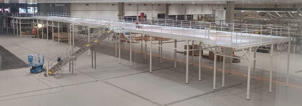 Plataforma metálica elevada com guarda-corpo em galpão de produção — Coca-Cola Andina (RJ)