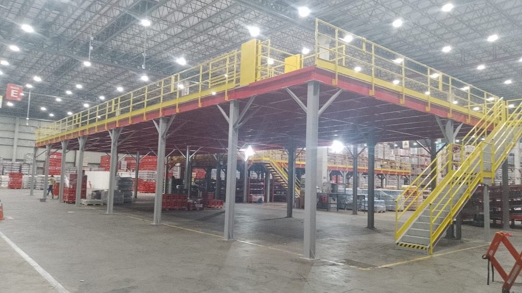 Mezanino metálico com estrutura vermelha, guarda-corpo e escada amarelos para estoque — Coca-Cola FEMSA ABC